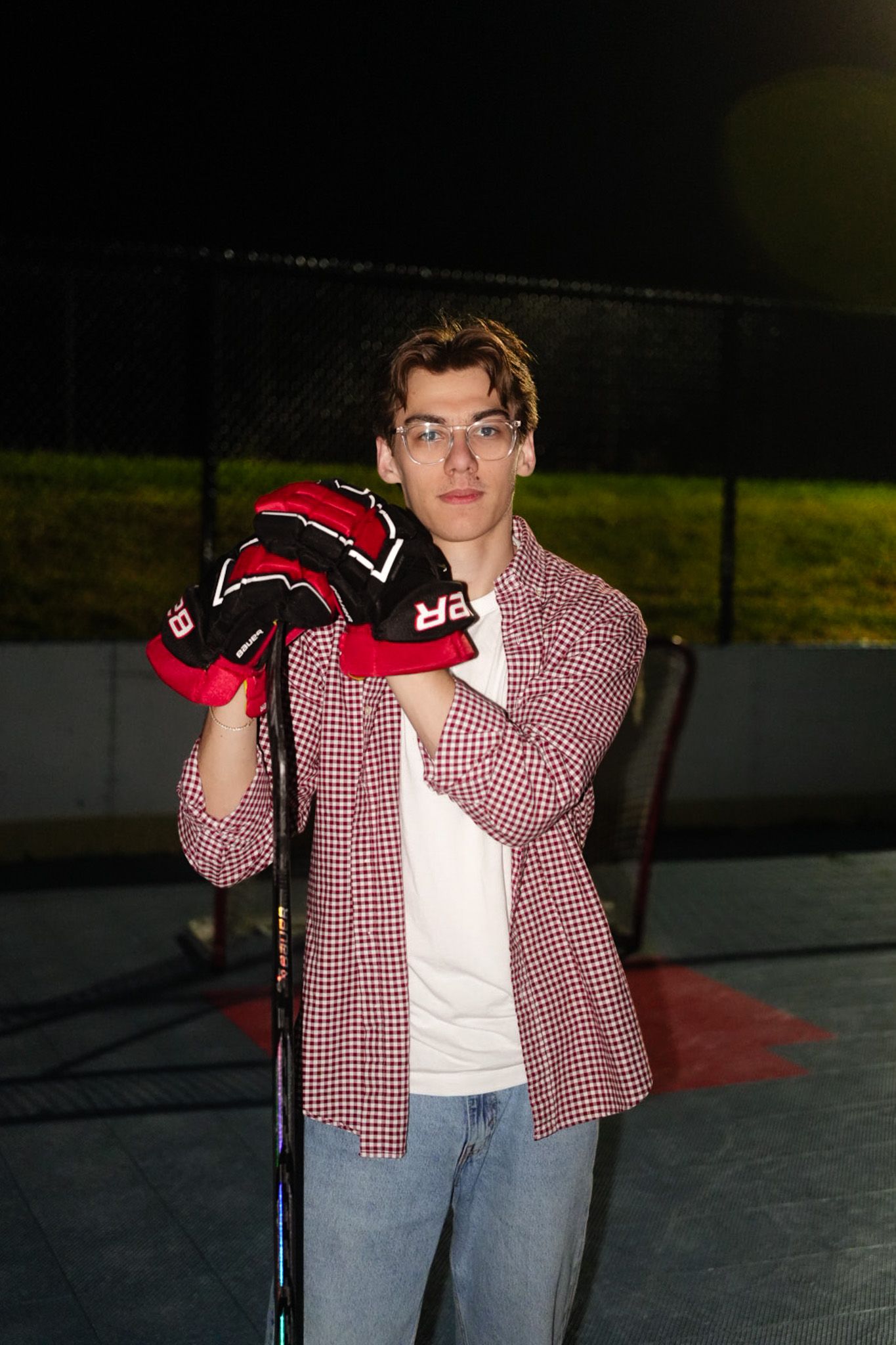 Flash portrait of Mikey Cabiles on the dek rink, gloves in hand.