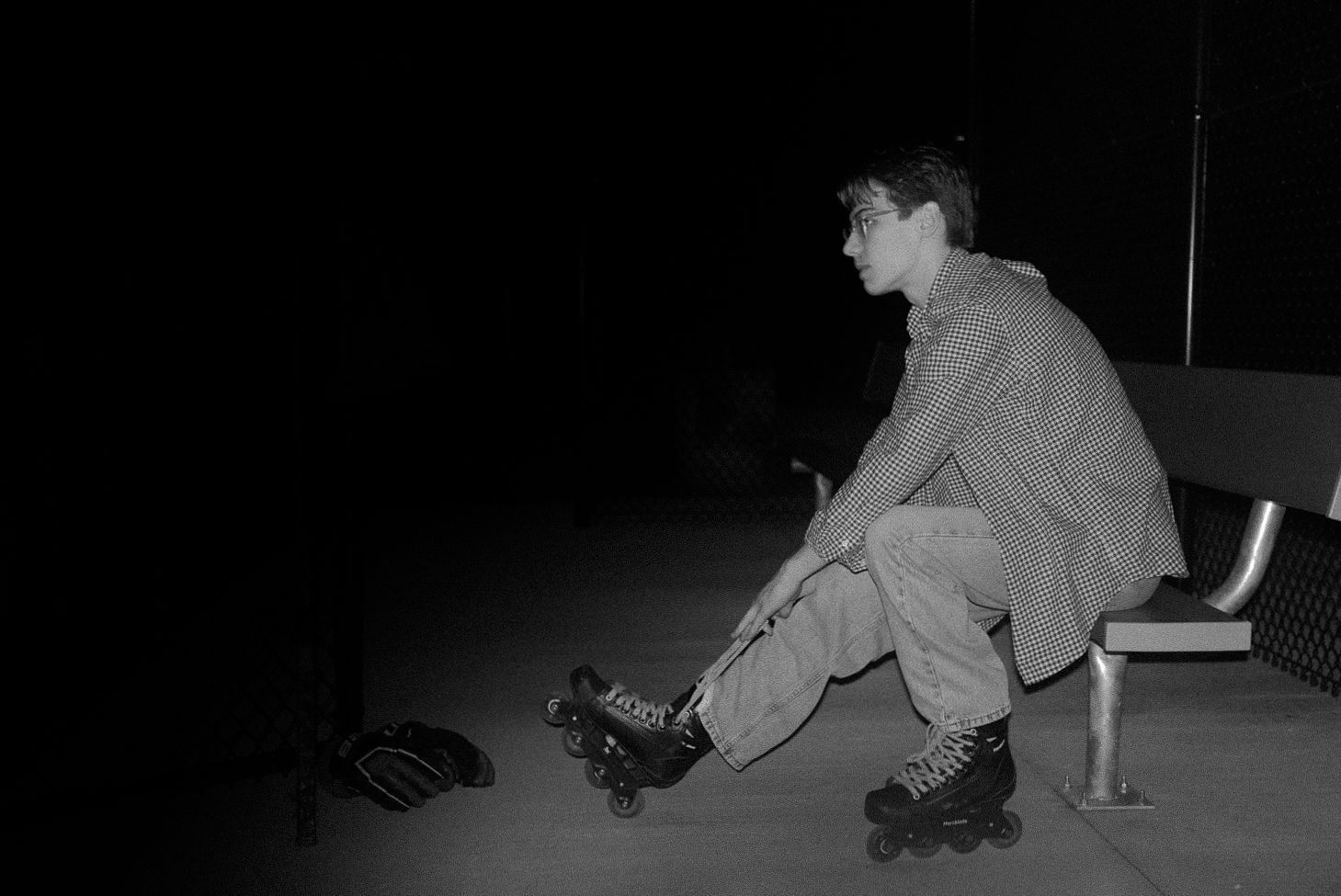 Mikey Cabiles lacing up under the lights — the quiet half of the work.