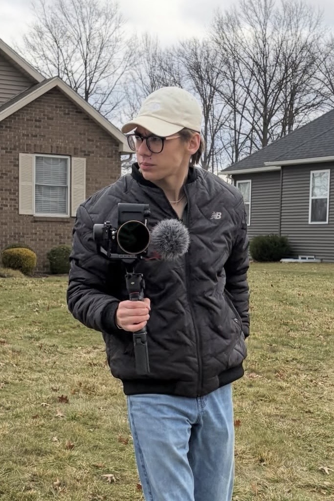 Mikey Cabiles filming on location with a camera and shotgun mic on a gimbal.